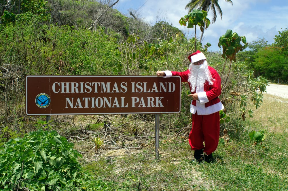 Santa standing beside the Christmas Island National Park sign