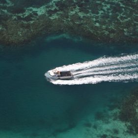 A boat travels over the corals below